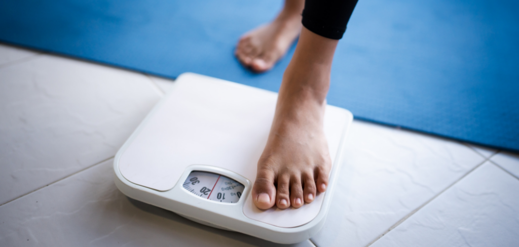 A woman weighs herself on scales