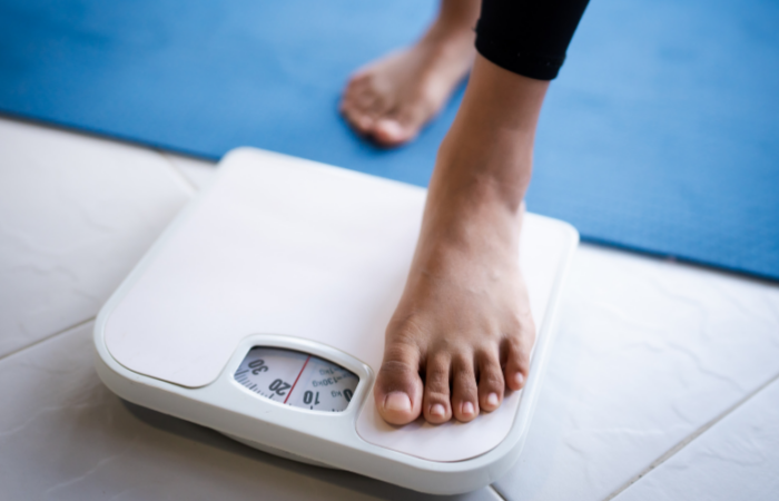 A woman weighs herself on scales