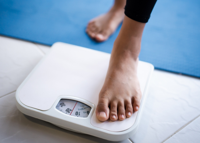 A woman weighs herself on scales