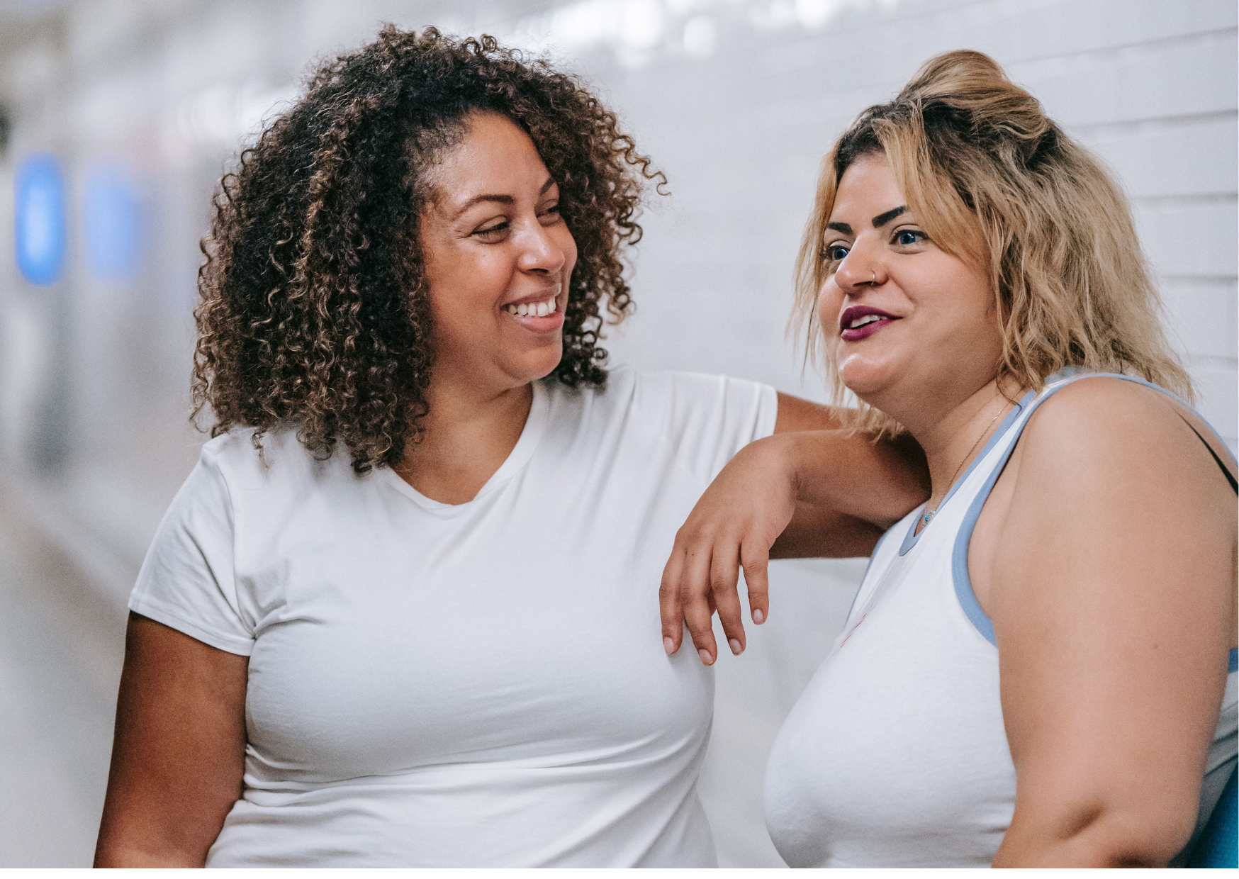 Two women standing and chatting happily
